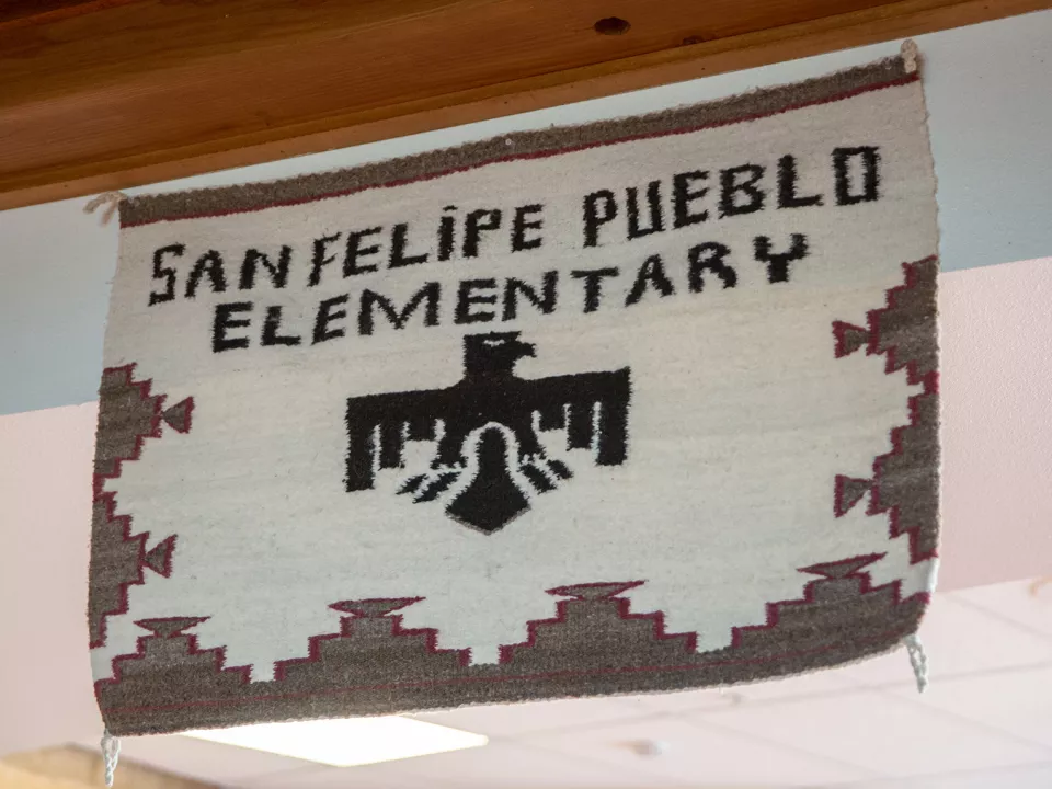 A woven tapestry that says San Felipe Pueblo Elementary with an eagle.