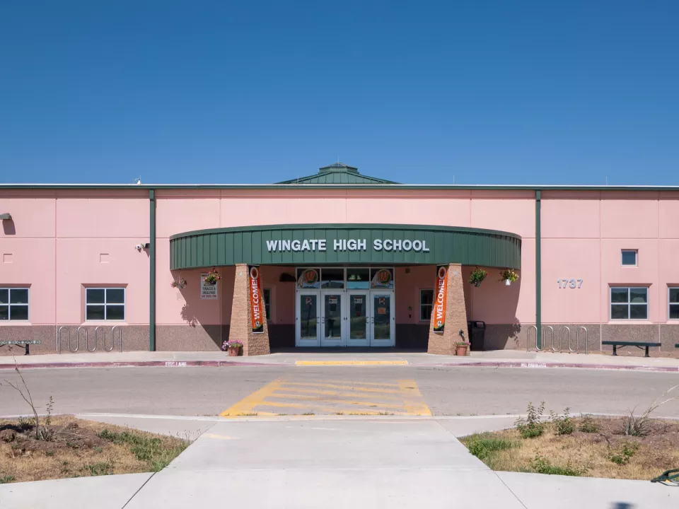 Front of a school building with columns and a curved roof.