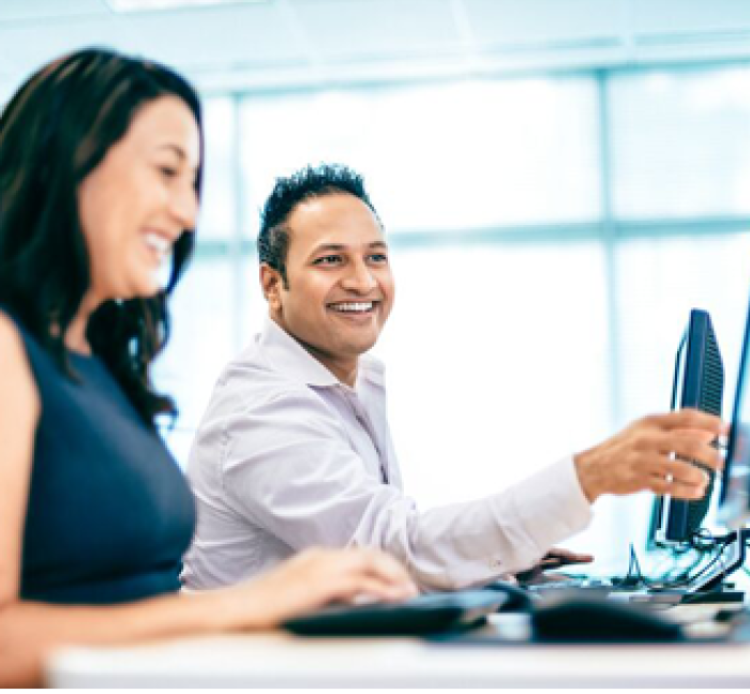 smiling man and woman working on a laptop together