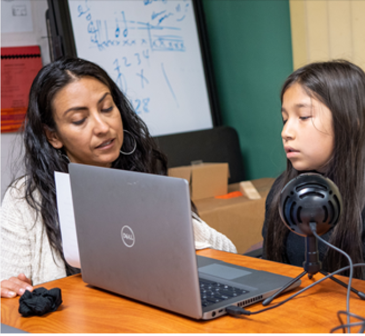 adult and child working together on laptop