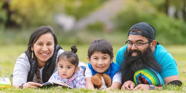 Native American family poses on grass.