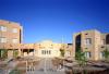 A wide shot of a high school against a bright blue sky.